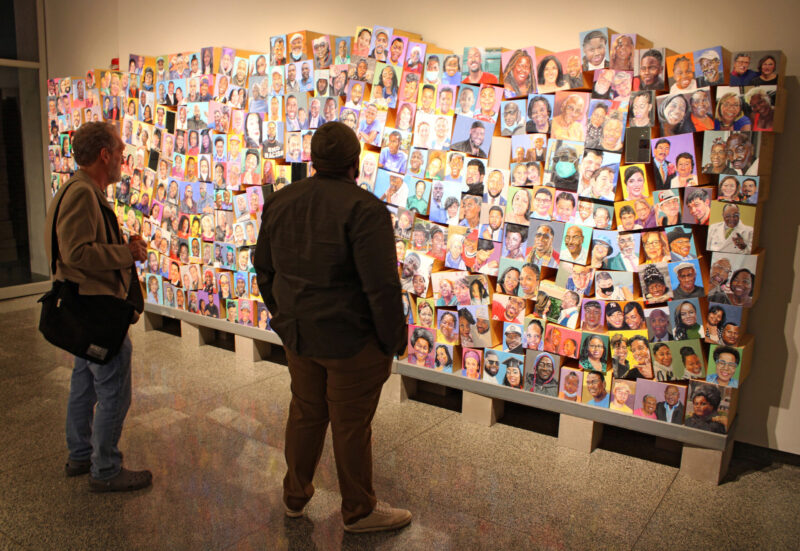 Two people looking at the Roseland Portrait Project in the Carlson Tower Gallery.