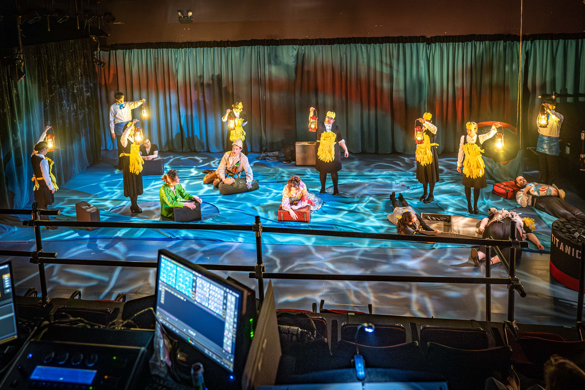 Students in a theatre performance on a stage.