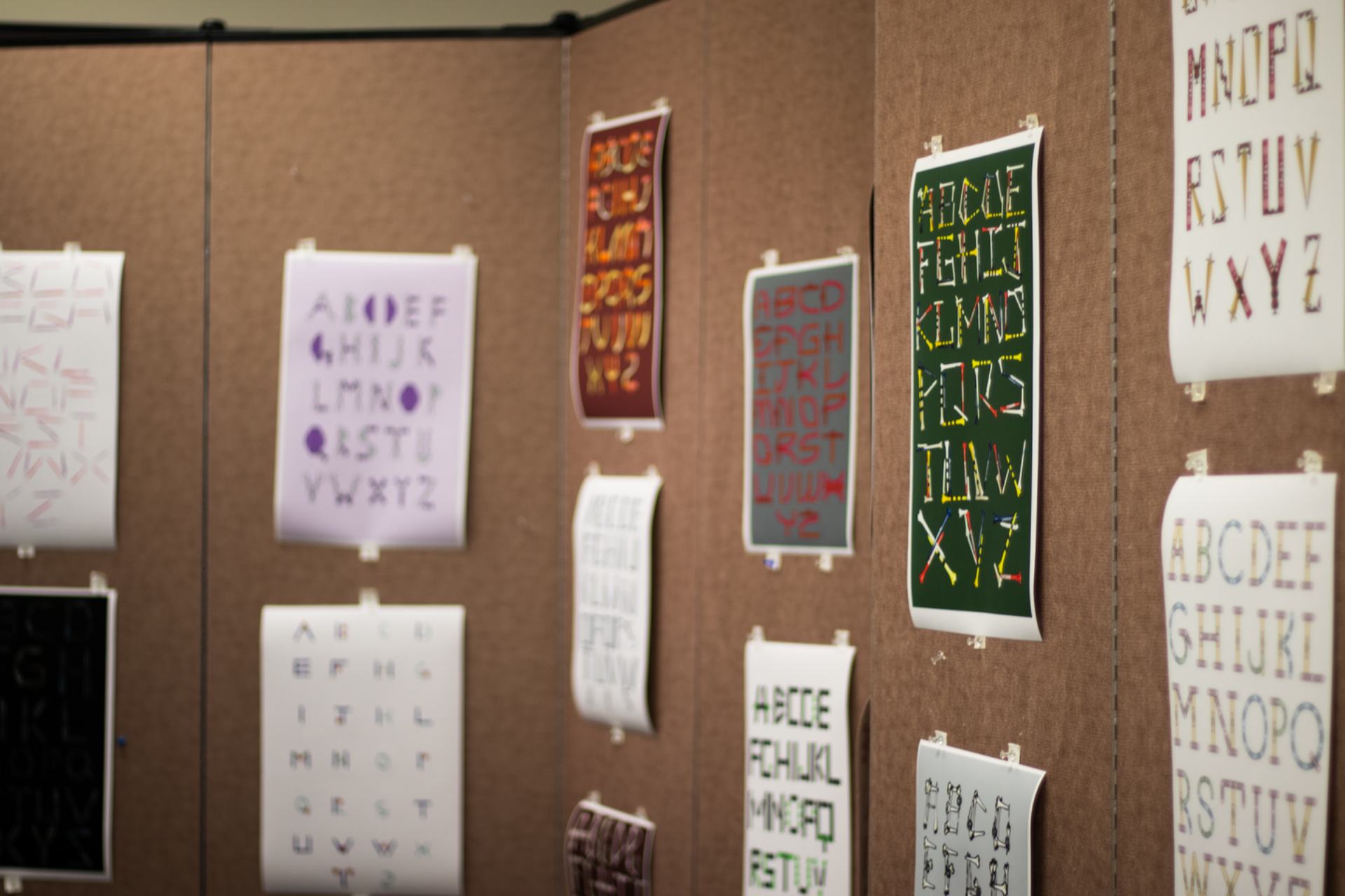 Graphic design work on paper hanging in a classroom on the walls.