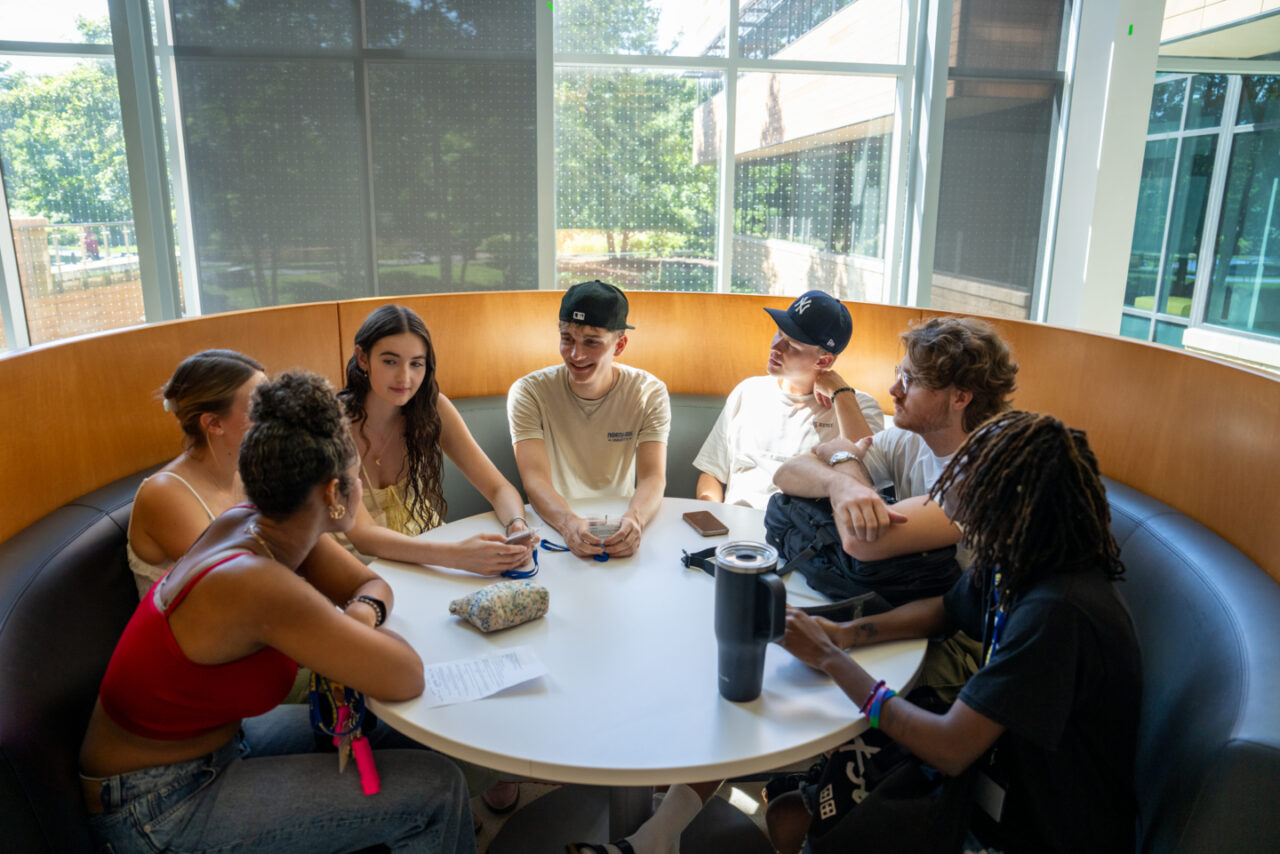 A group of students sitting around a table in the lobby of the Johnson Center at North Park University.