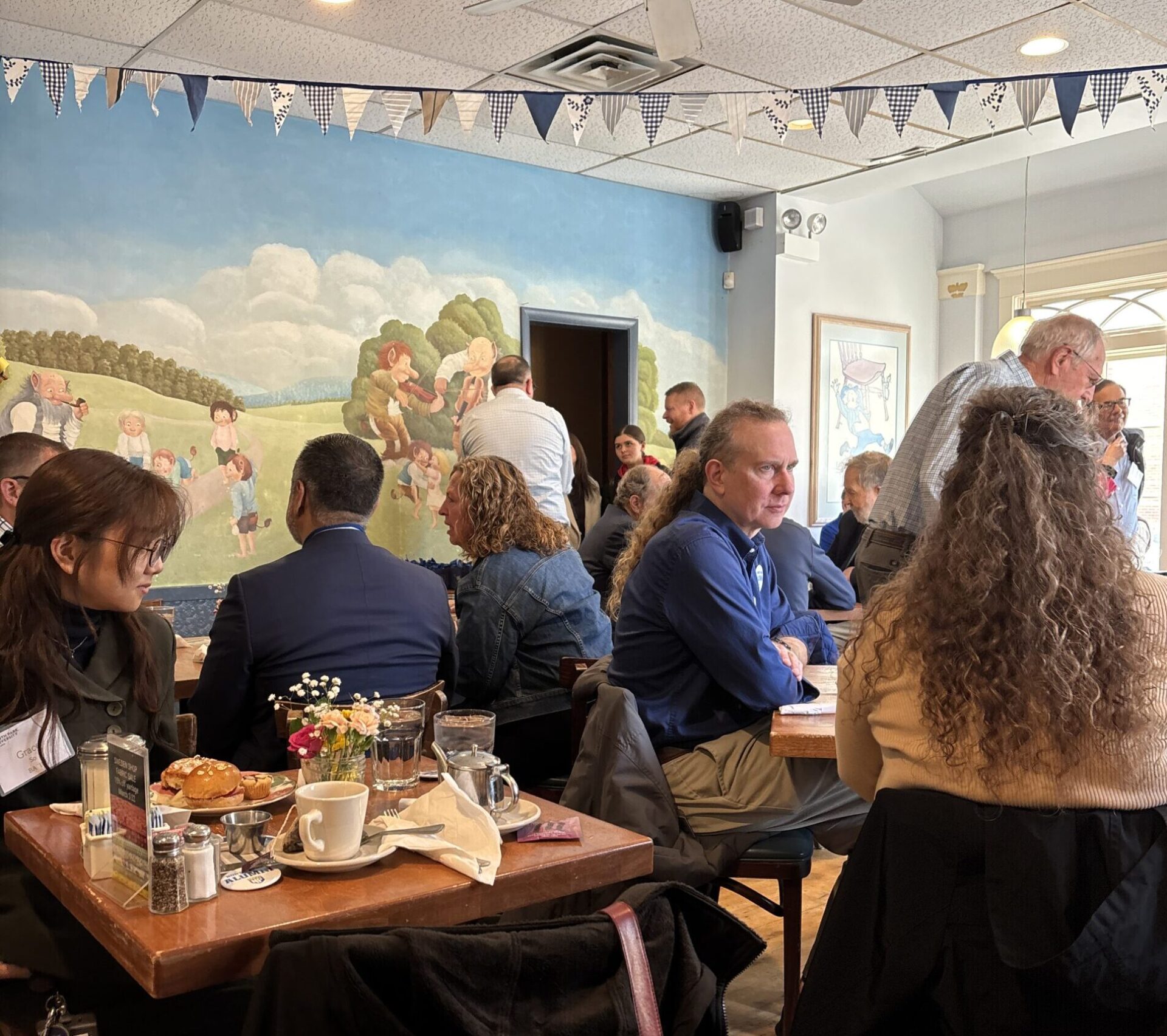 Individuals sitting in a restaurant conversing with each other.