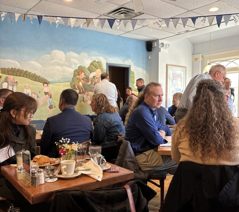 Individuals sitting in a restaurant conversing with each other.