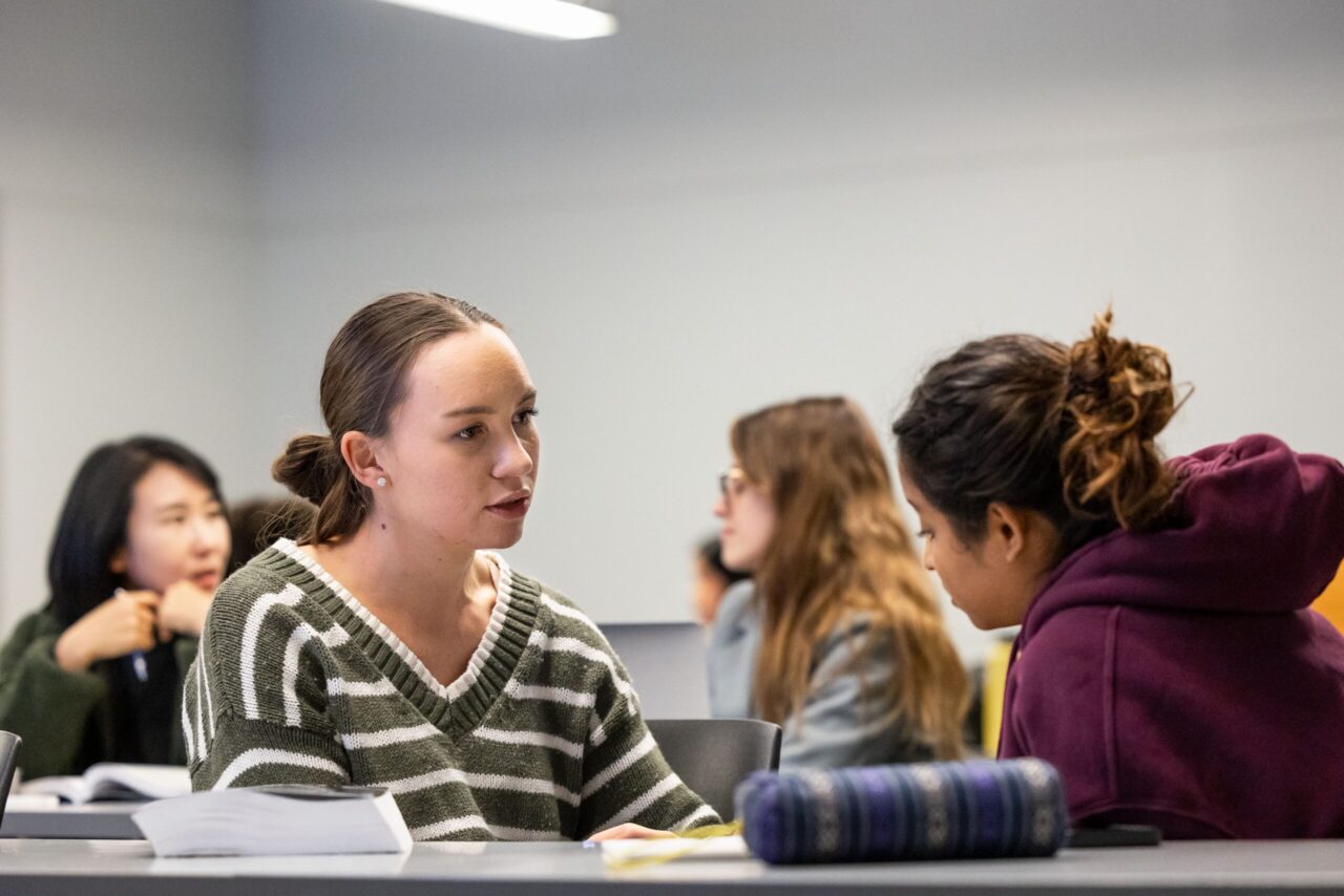 Students facing each other while in discussion in a classroom.