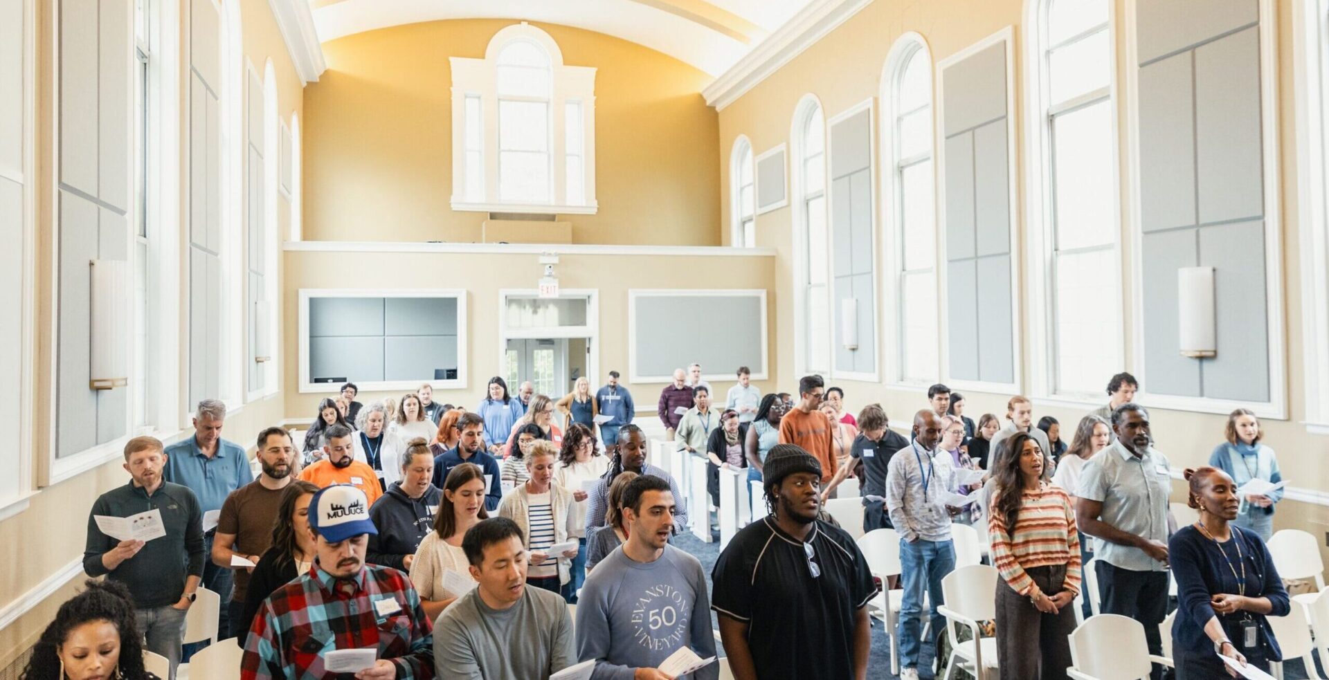 People gathered in a chapel, singing.